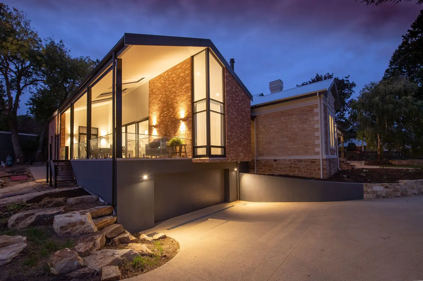 Modern brick home lit up at dusk