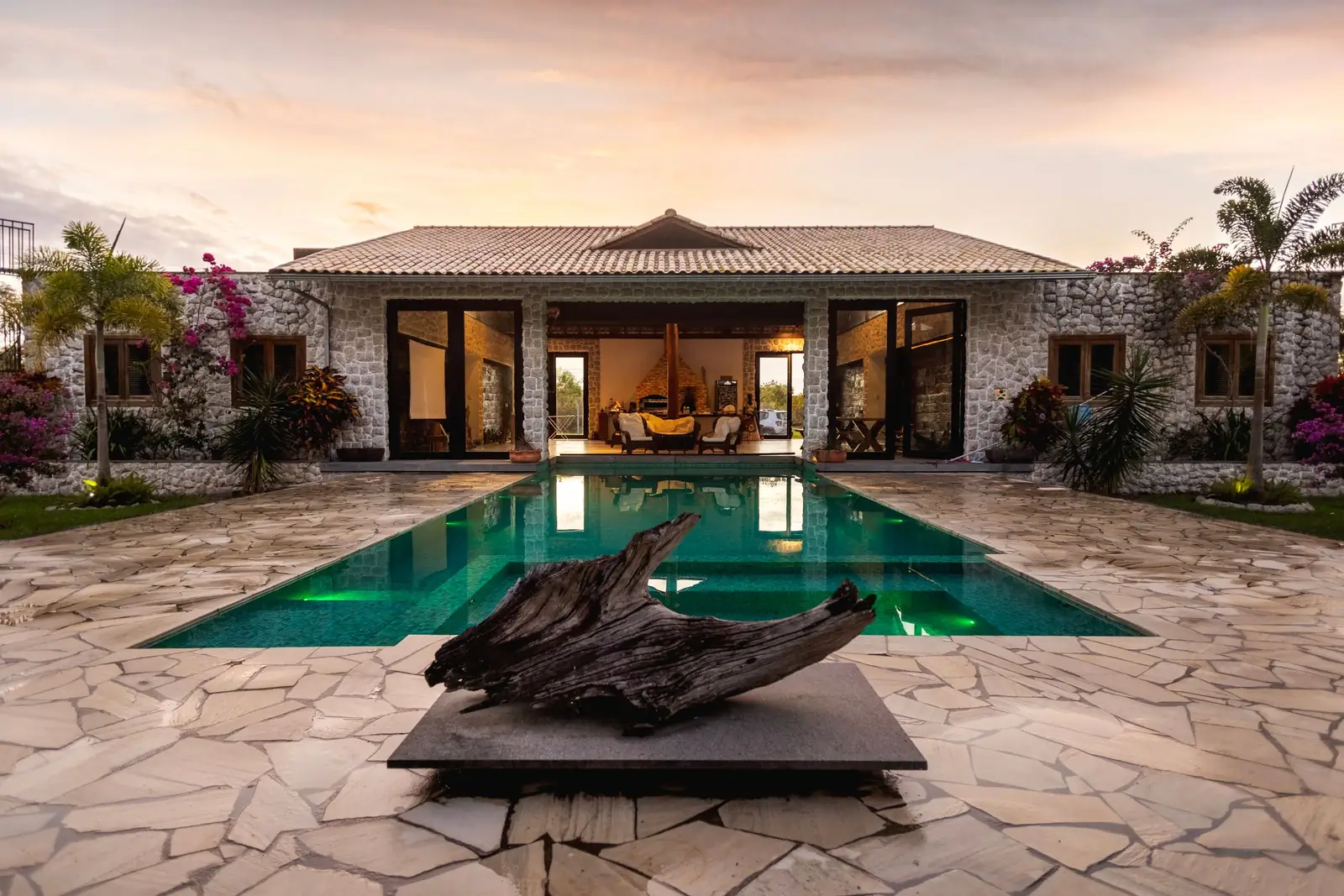 Home with a swimming pool at sunset